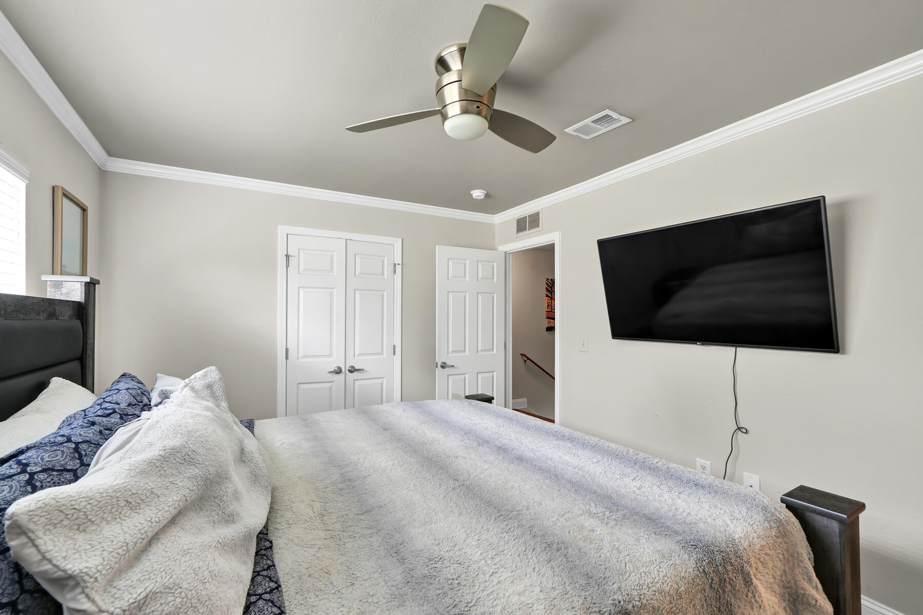 562 Wingspan Way Crestview, FL 32536 - Photo 19 of 23 a bedroom with a bed a flat screen tv and a ceiling fan