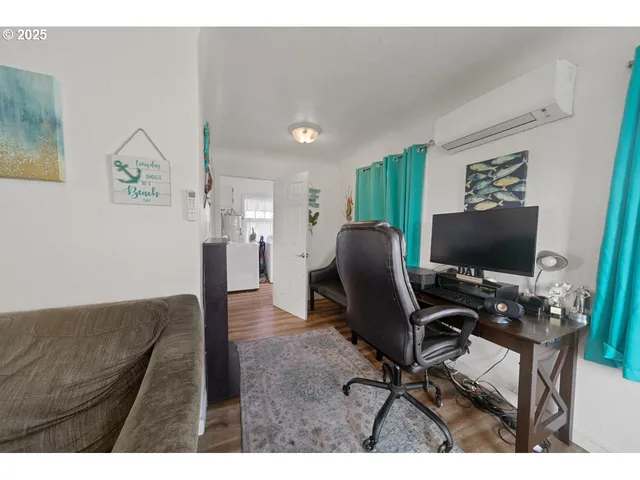a view of a workspace with furniture and a flat screen tv