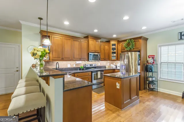 a kitchen with stainless steel appliances granite countertop sink stove and refrigerator