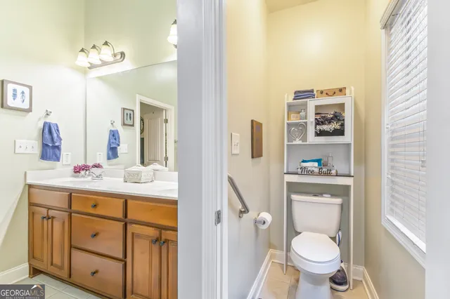 a bathroom with a granite countertop toilet sink and mirror