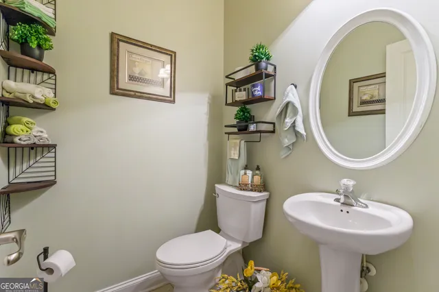 a bathroom with a toilet sink and mirror