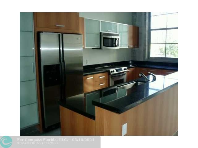 a kitchen with stainless steel appliances a microwave a sink and a stove