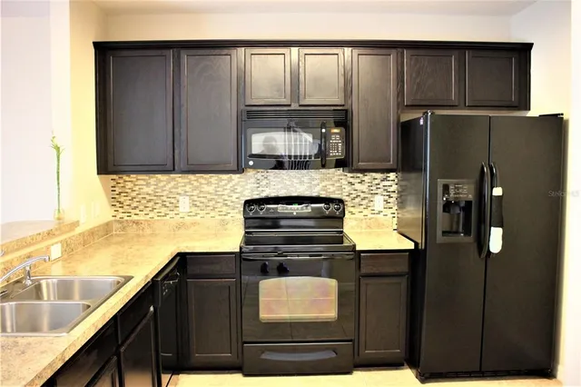 a kitchen with a refrigerator and a stove