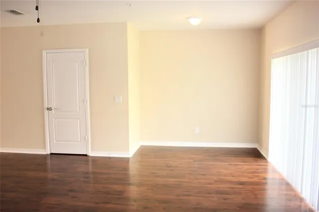 a view of an empty room with wooden floor