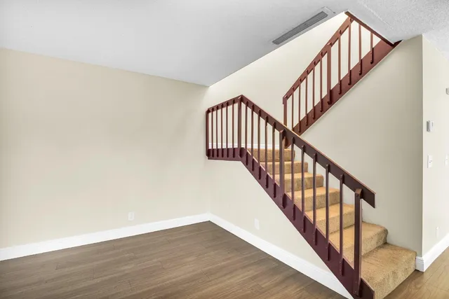 a view of staircase with wooden floor and white walls