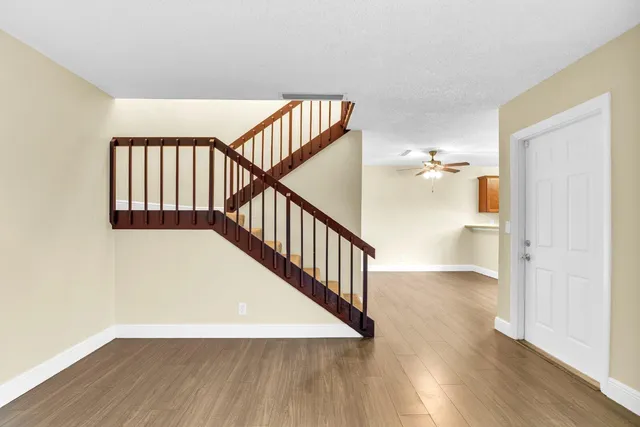 a view of a hallway with wooden floor and stairs