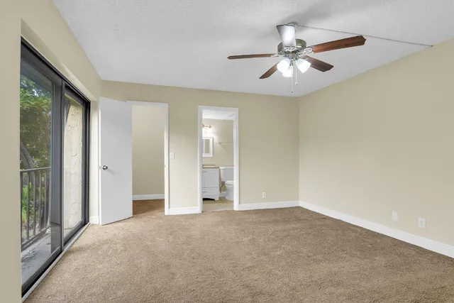 an empty room with fan and windows