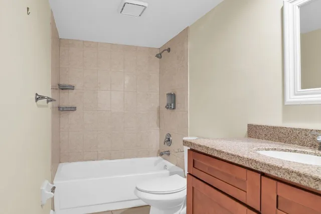 a bathroom with a granite countertop toilet a sink and bathtub
