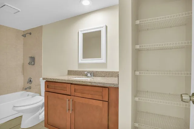 a bathroom with a granite countertop sink toilet and shower