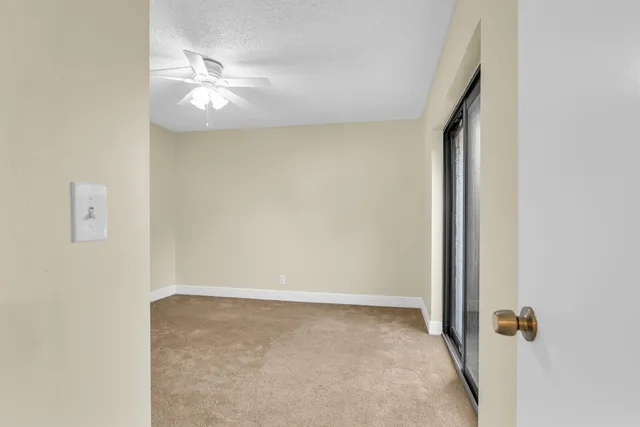 an empty room with a chandelier fan