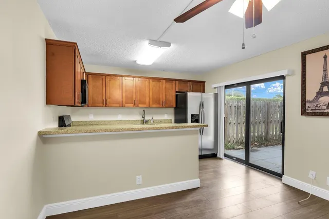a view of a kitchen with stainless steel appliances granite countertop a refrigerator and a sink