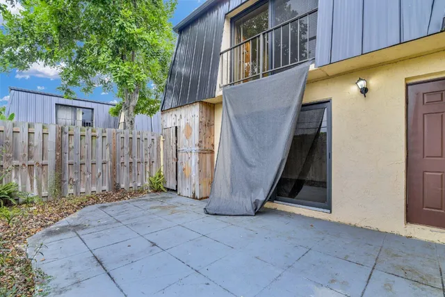 a view of a house with backyard and wooden fence