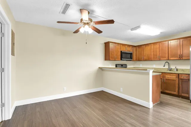 a view of a kitchen with a sink cabinets and wooden floor