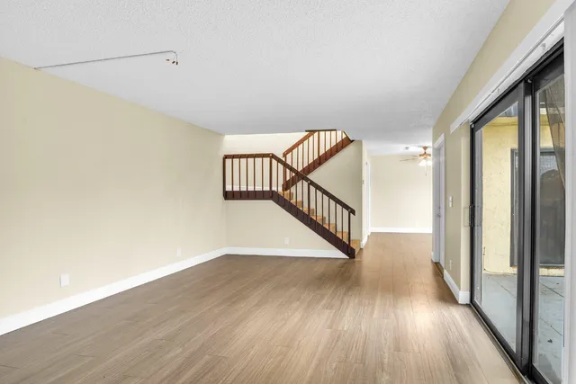 a view of a hallway with wooden floor and a floor to ceiling window