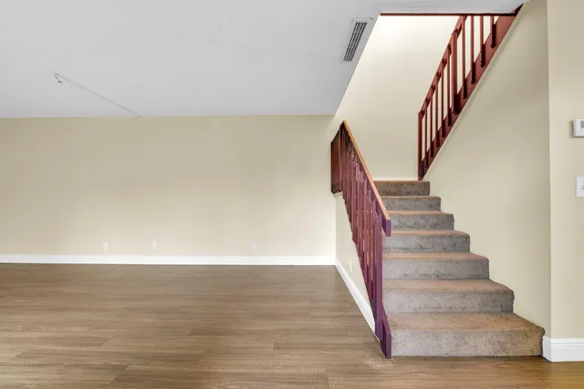 a view of staircase with wooden floor and white walls