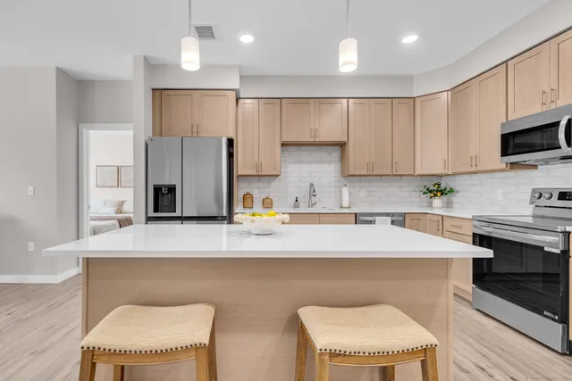 a kitchen with stainless steel appliances granite countertop a sink refrigerator and cabinets