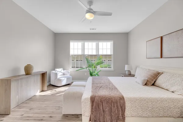 a spacious bedroom with a bed and wooden floor