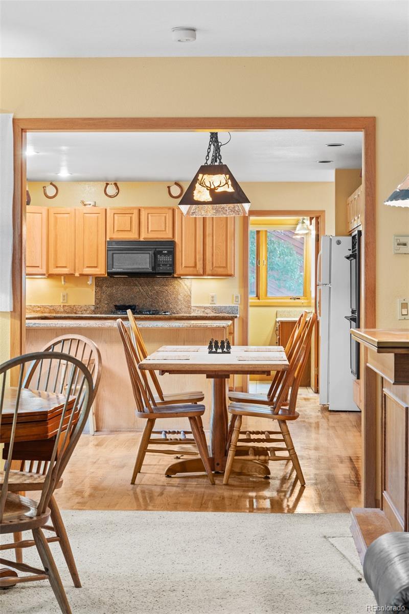 868 Deer Path Road Dillon, CO 80435 - Photo 27 of 50 a living room with a couch and a dining table with wooden floor