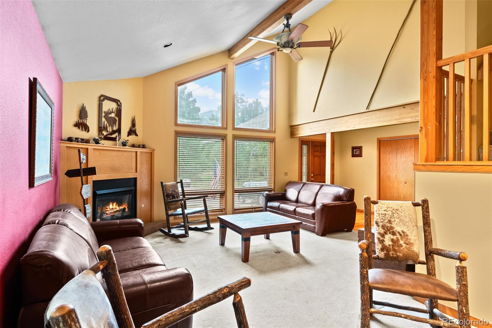 868 Deer Path Road Dillon, CO 80435 - Photo 10 of 50 a living room with furniture a fireplace and floor to ceiling windows