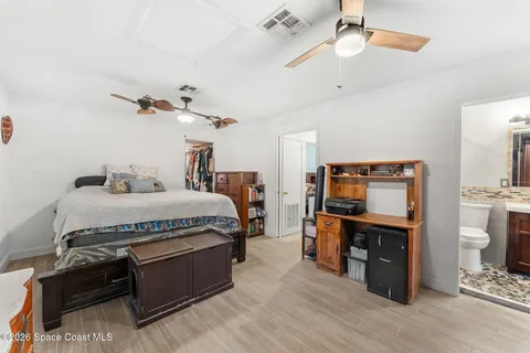 a bedroom with a bed and a flat tv screen on the dresser