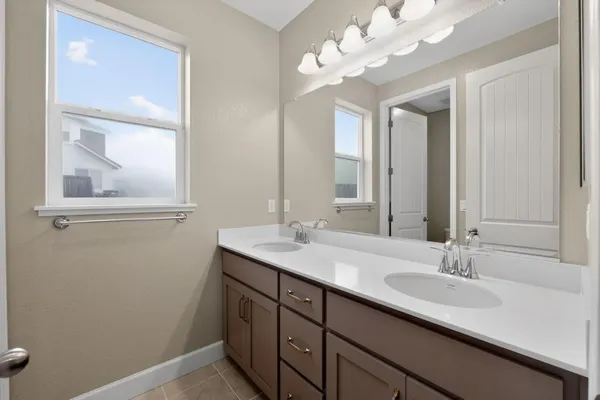 a spacious bathroom with a bathtub shower sink mirror and toilet