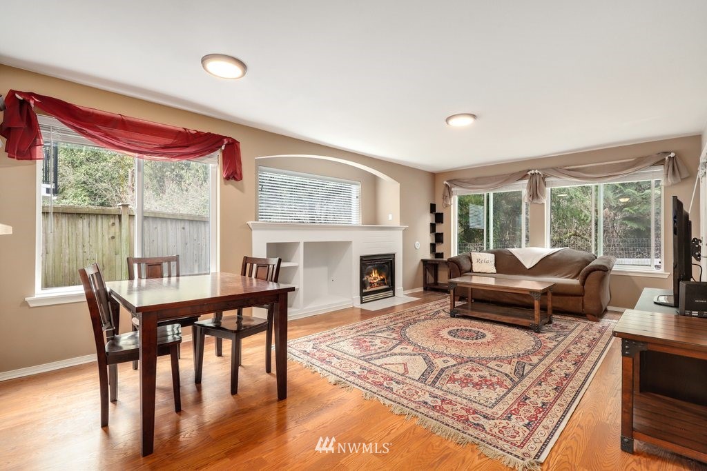 2201 192nd Street Southeast, Unit S101 Bothell, WA 98012 - Photo 3 of 33 a living room with furniture a fireplace and large windows