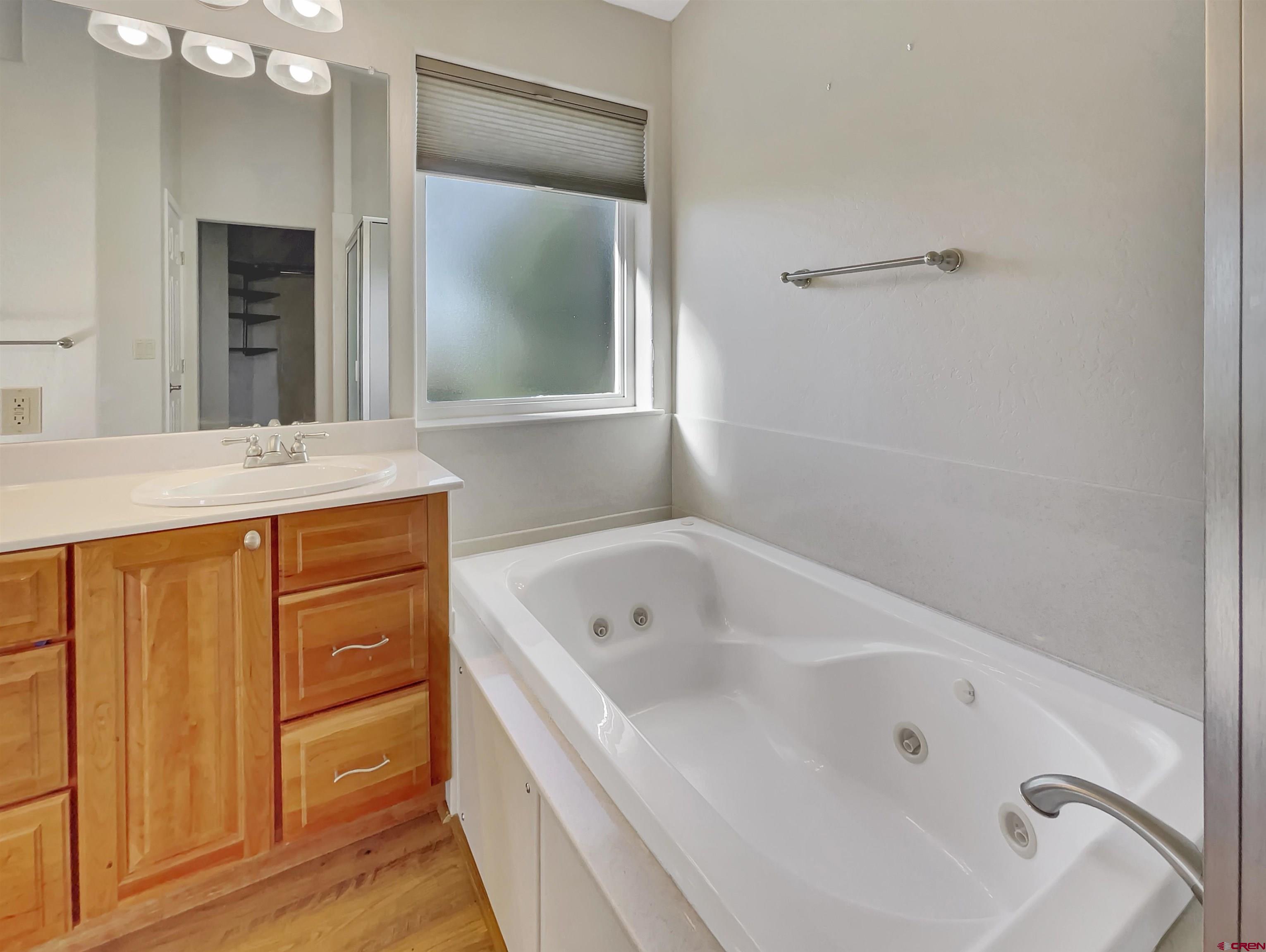 12863 24.4 Road Cortez, CO 81321 - Photo 18 of 35 a bathroom with a tub sink and mirror