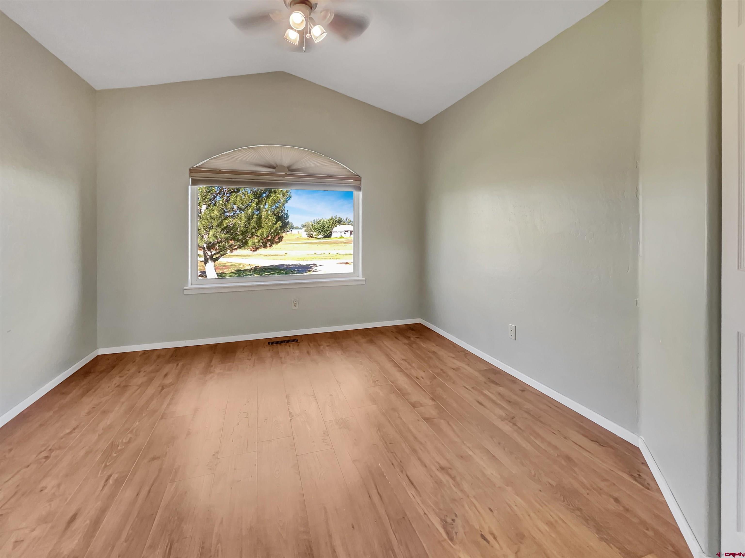 12863 24.4 Road Cortez, CO 81321 - Photo 20 of 35 an empty room with wooden floor and windows