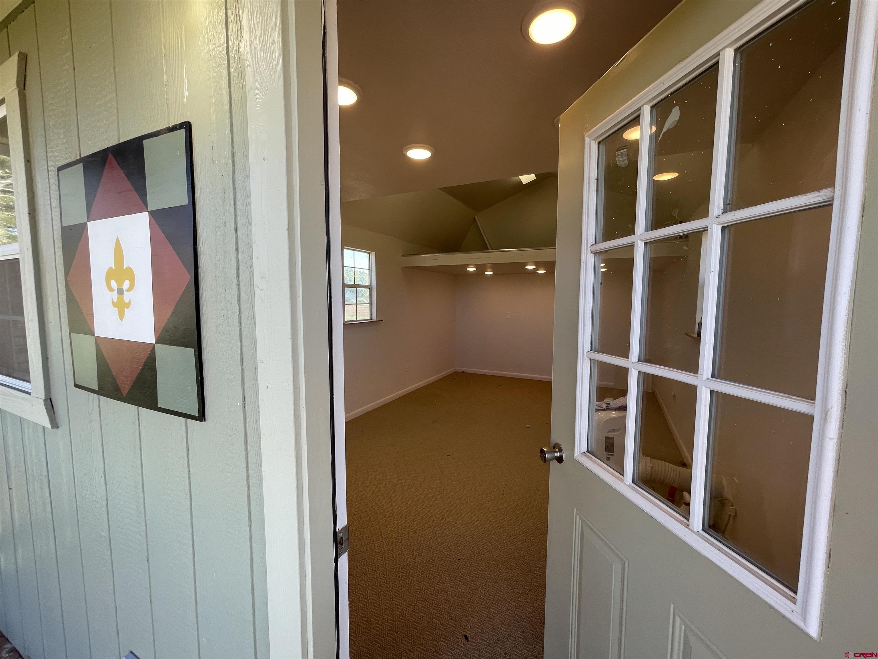 12863 24.4 Road Cortez, CO 81321 - Photo 32 of 35 a view of a hallway with wooden floor and staircase
