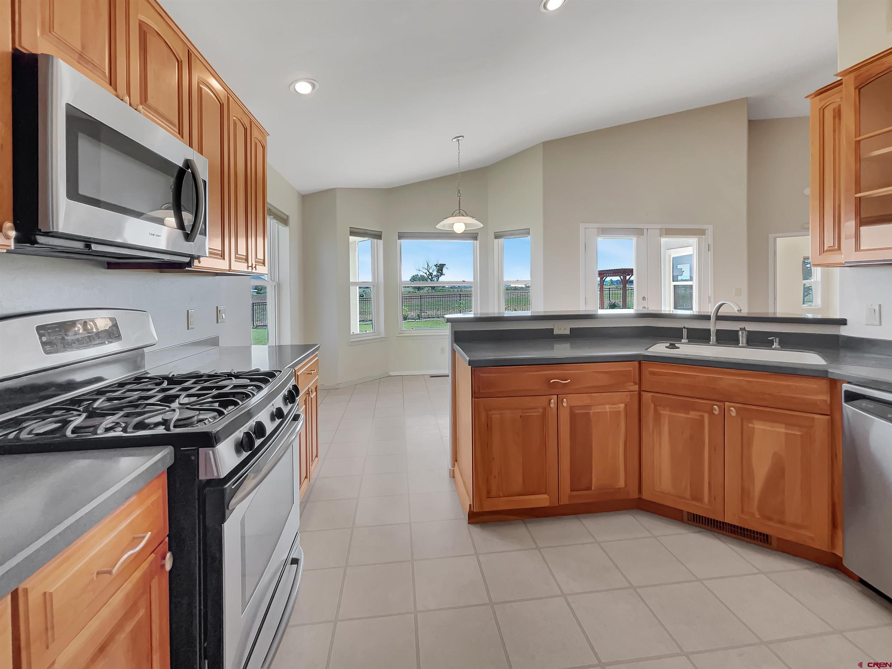 12863 24.4 Road Cortez, CO 81321 - Photo 9 of 35 a kitchen with stainless steel appliances granite countertop a stove a sink and a microwave