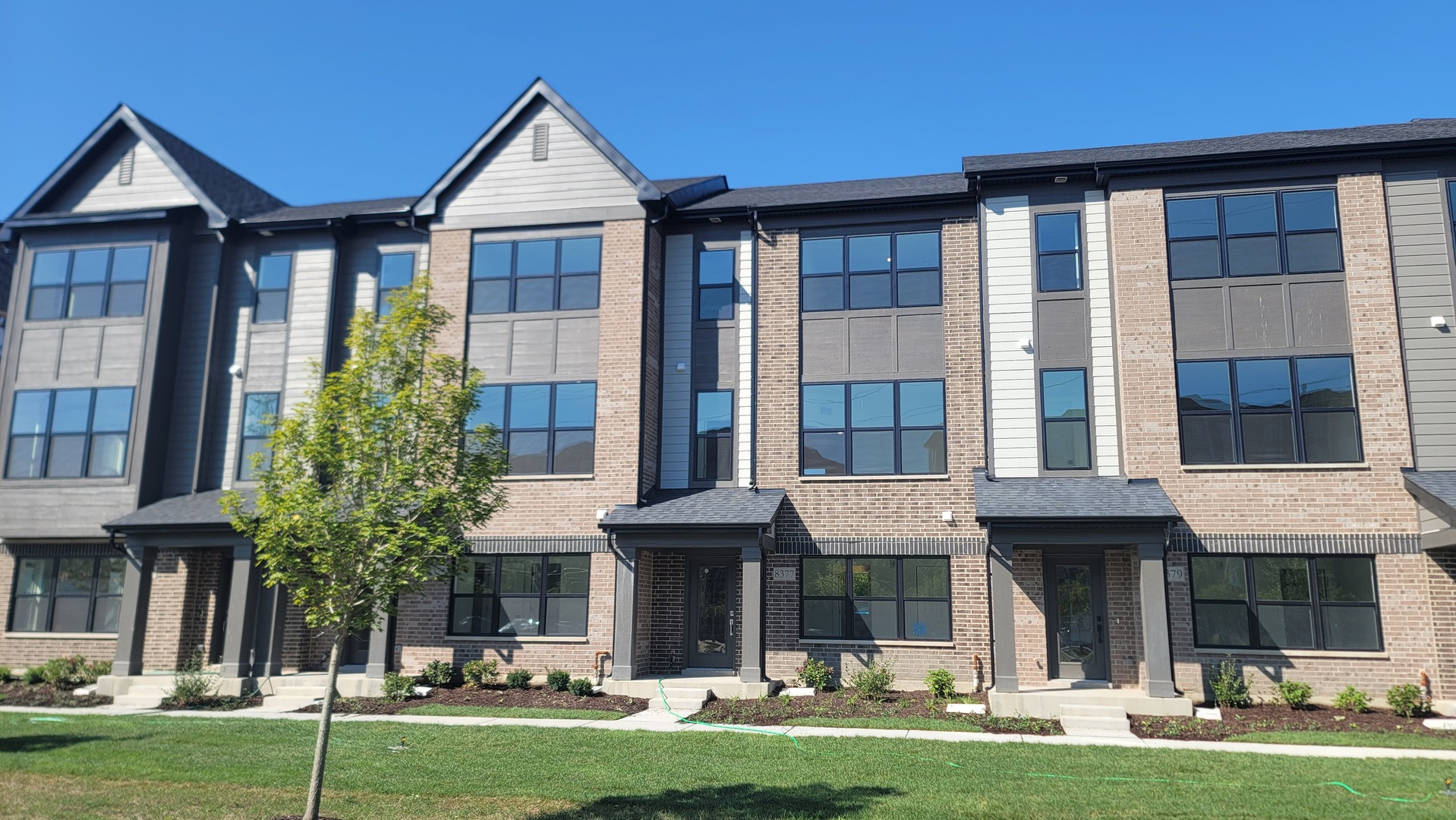 a front view of a brick building with a yard