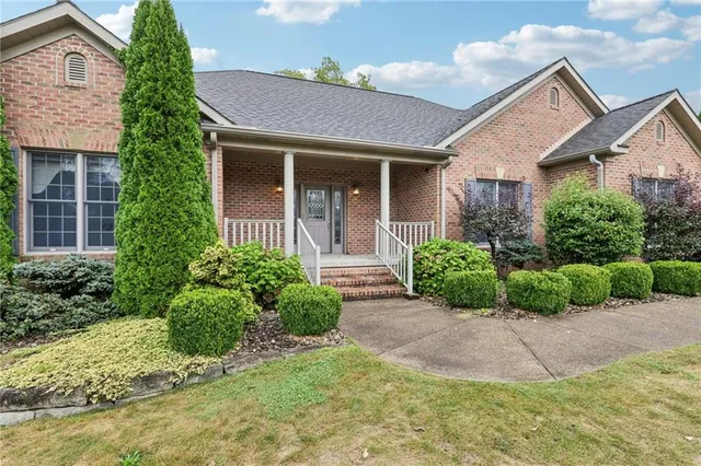 a front view of a house with a yard and potted plants