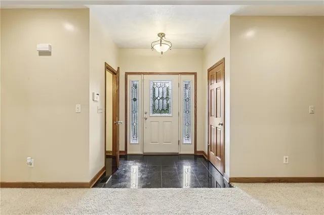 wooden floor in a hall with a window and a refrigerator