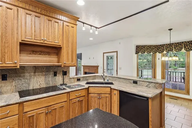 a kitchen with granite countertop a sink stove and cabinets