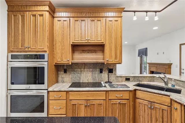 a kitchen with stainless steel appliances granite countertop a sink stove and cabinets