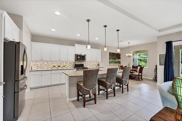 a kitchen with stainless steel appliances kitchen island granite countertop a sink a stove and a refrigerator