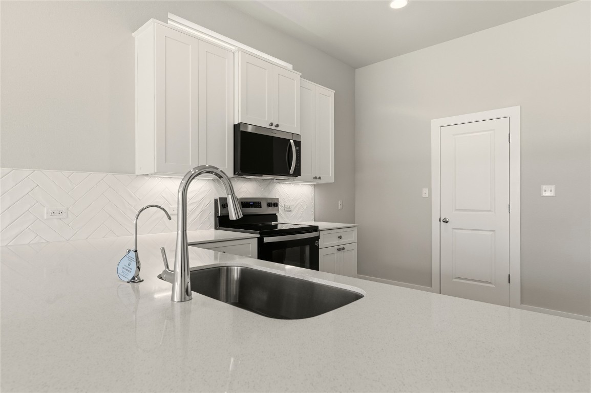 2206 Luna Azul View, Unit 78 Round Rock, TX 78664 - Photo 10 of 31 Kitchen featuring backsplash, white cabinetry, appliances with stainless steel finishes, light stone counters, and recessed lighting