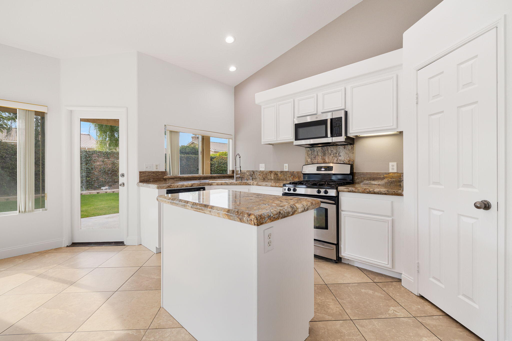 80601 Declaration Avenue Indio, CA 92201 - Photo 23 of 52 a kitchen with stainless steel appliances granite countertop a stove top oven a sink a counter top space cabinets and a window