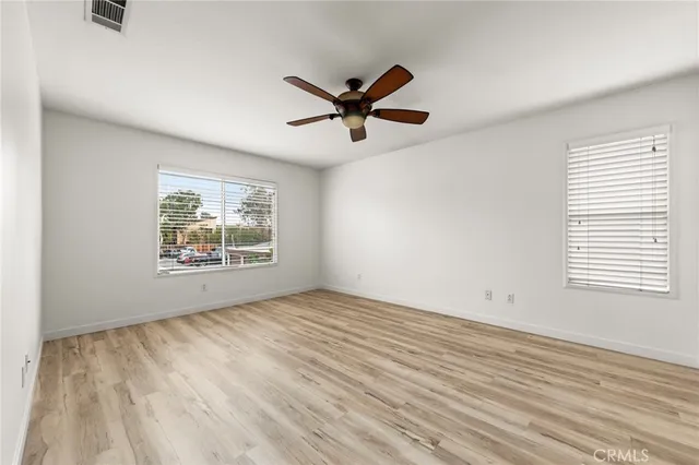 a view of a big room with wooden floor and a ceiling fan