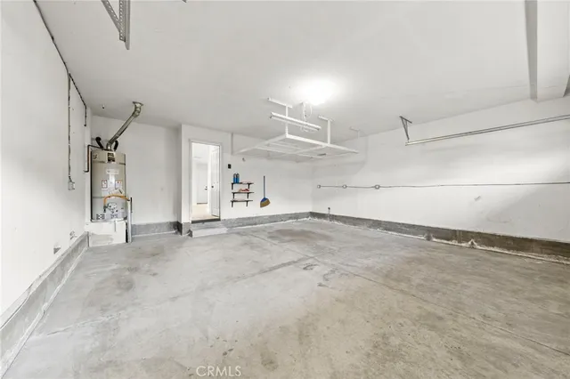 a view of a white house with a large space and large trees