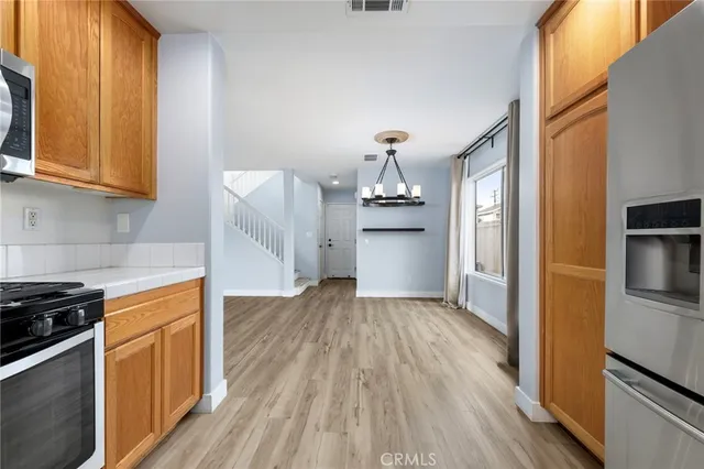 a kitchen with granite countertop wooden floors and stainless steel appliances