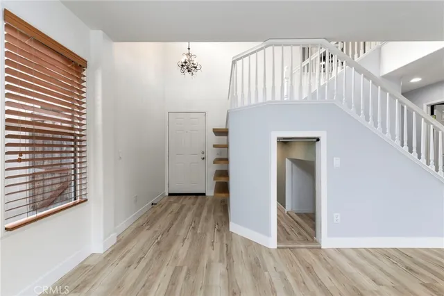 a view of a hallway with wooden floor and staircase