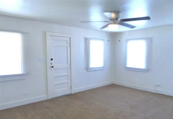 en empty room with windows and fan