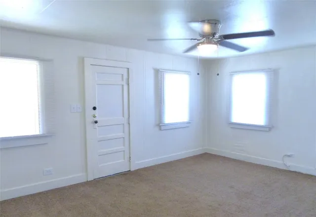 en empty room with windows and fan