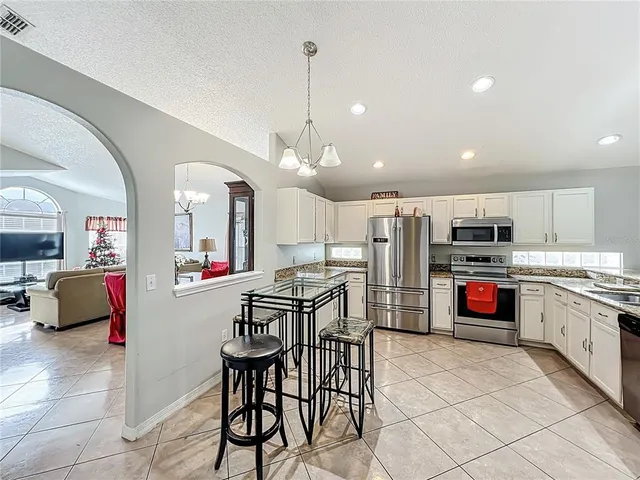 a kitchen with stainless steel appliances kitchen island granite countertop a refrigerator and a stove top oven