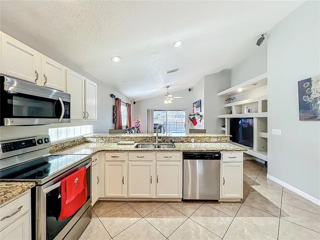 a kitchen with a sink stove top oven and microwave