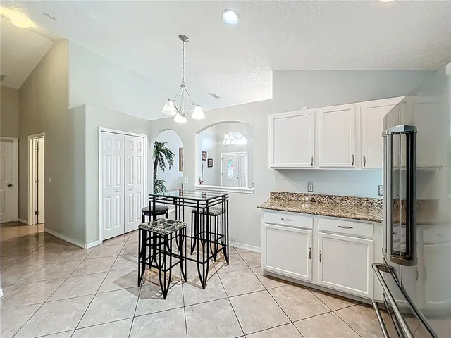 a view of a kitchen with granite countertop stainless steel appliances and a dining table