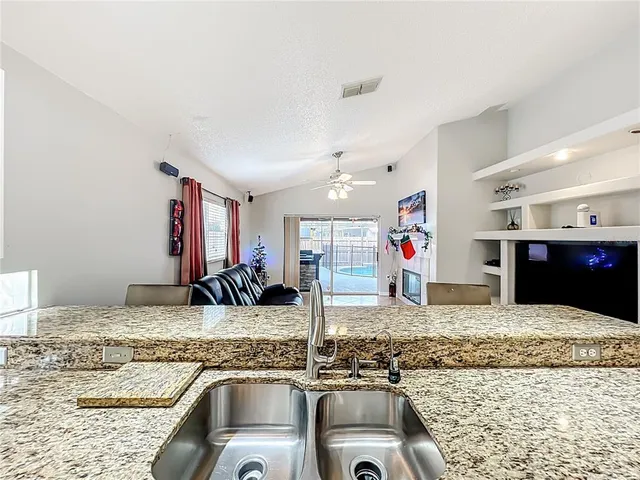 a kitchen with kitchen island granite countertop a sink and a stove