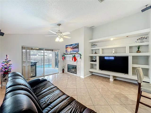 a living room with furniture a flat screen tv and a floor to ceiling window