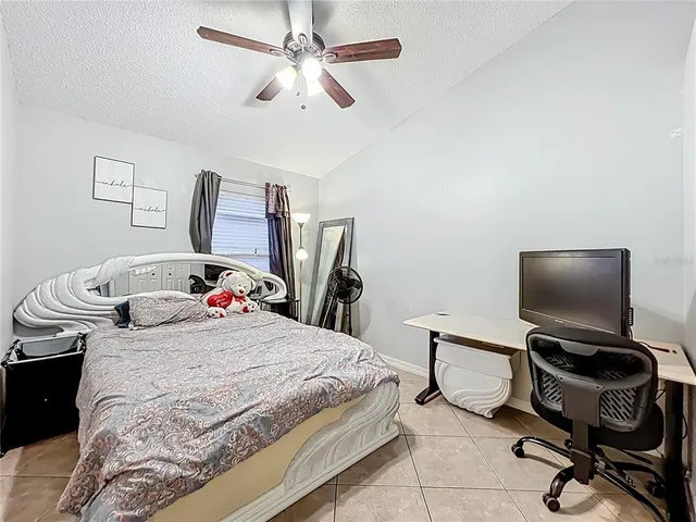 a bedroom with a bed and a desk with chair